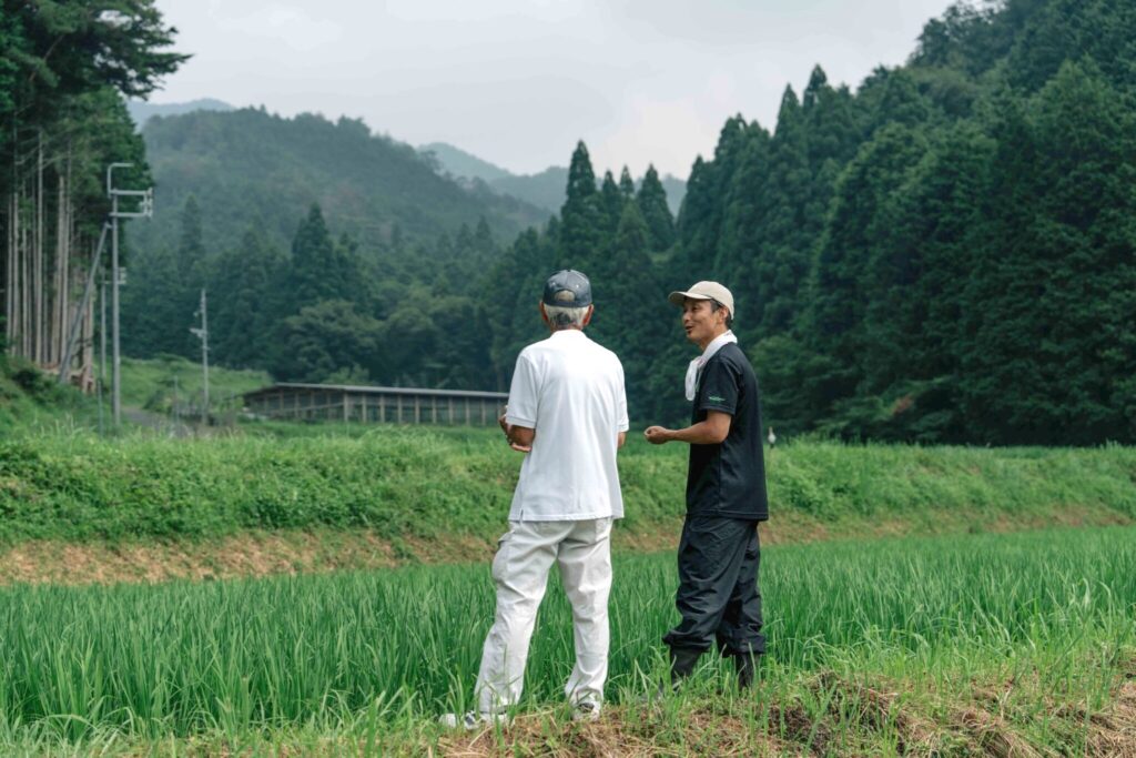 米農家の高木さんと取締役の羽田が話している様子